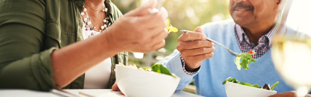 Two people eating bowls of salad